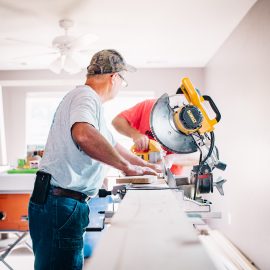 A male contractor at work on a large saw within a home