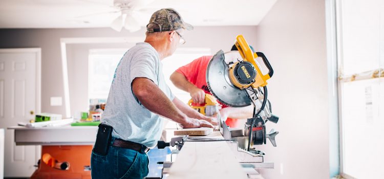 A male contractor at work on a large saw within a home