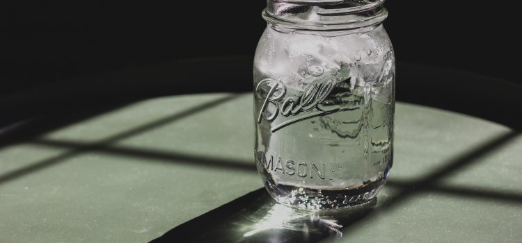 Mason jar filled with ice water on a table